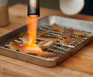 Chef applying fire to seafood